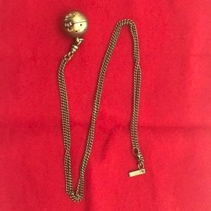 Perfume holding long necklace.